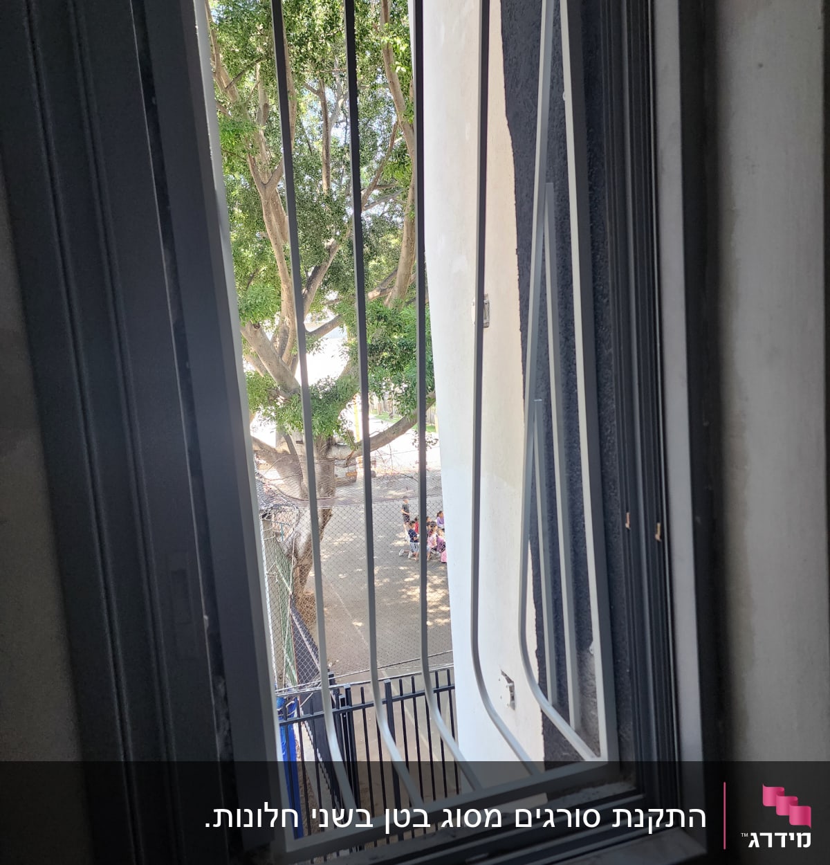 חלון עם סורגים מתכתיים ומסגרת שחורה